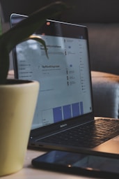 white ceramic mug on black laptop computer