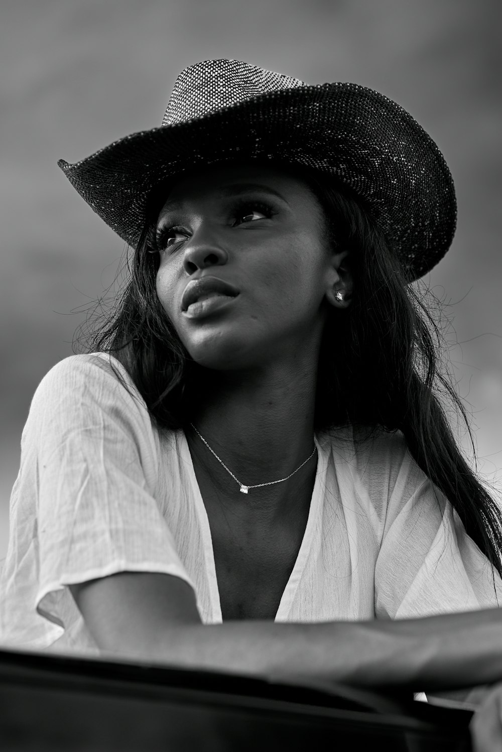 woman in white v neck shirt wearing black hat