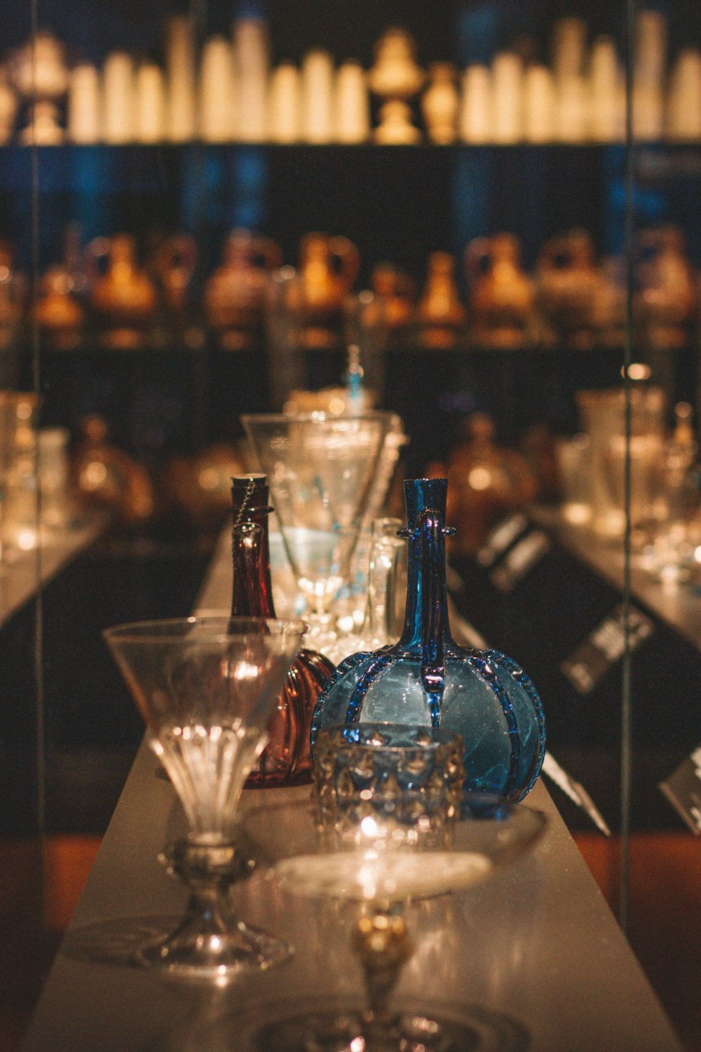 blue glass bottle beside drinking glass on table