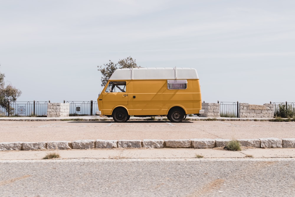 yellow van on gray concrete road during daytime