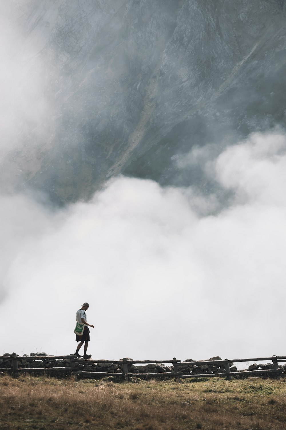 man in black jacket standing on rock mountain