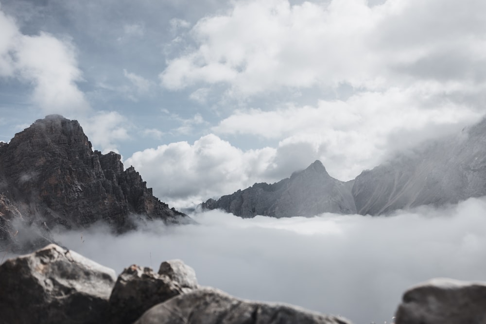 snow covered mountain near body of water under cloudy sky during daytime