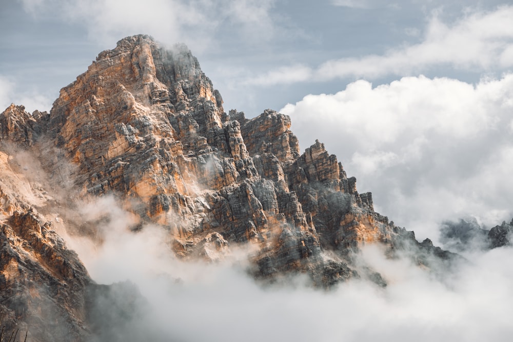 brown and white mountain under white clouds