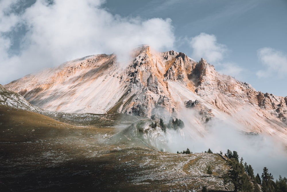 brown and white mountain under white clouds during daytime