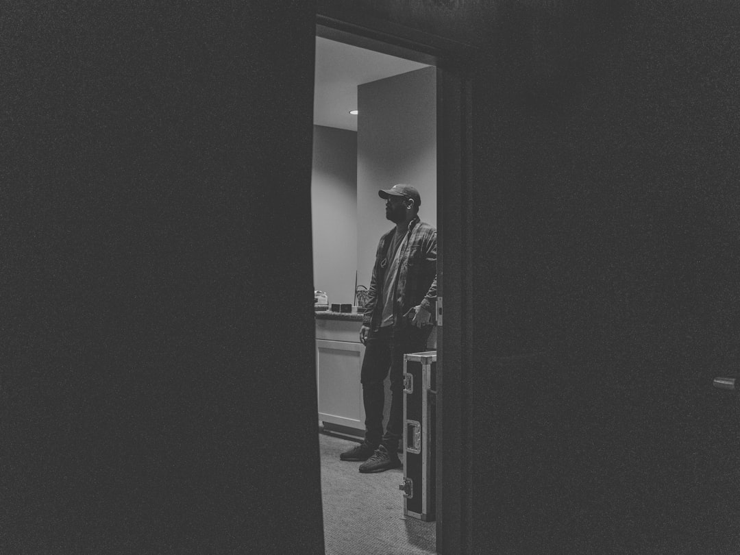 man in black coat walking on hallway