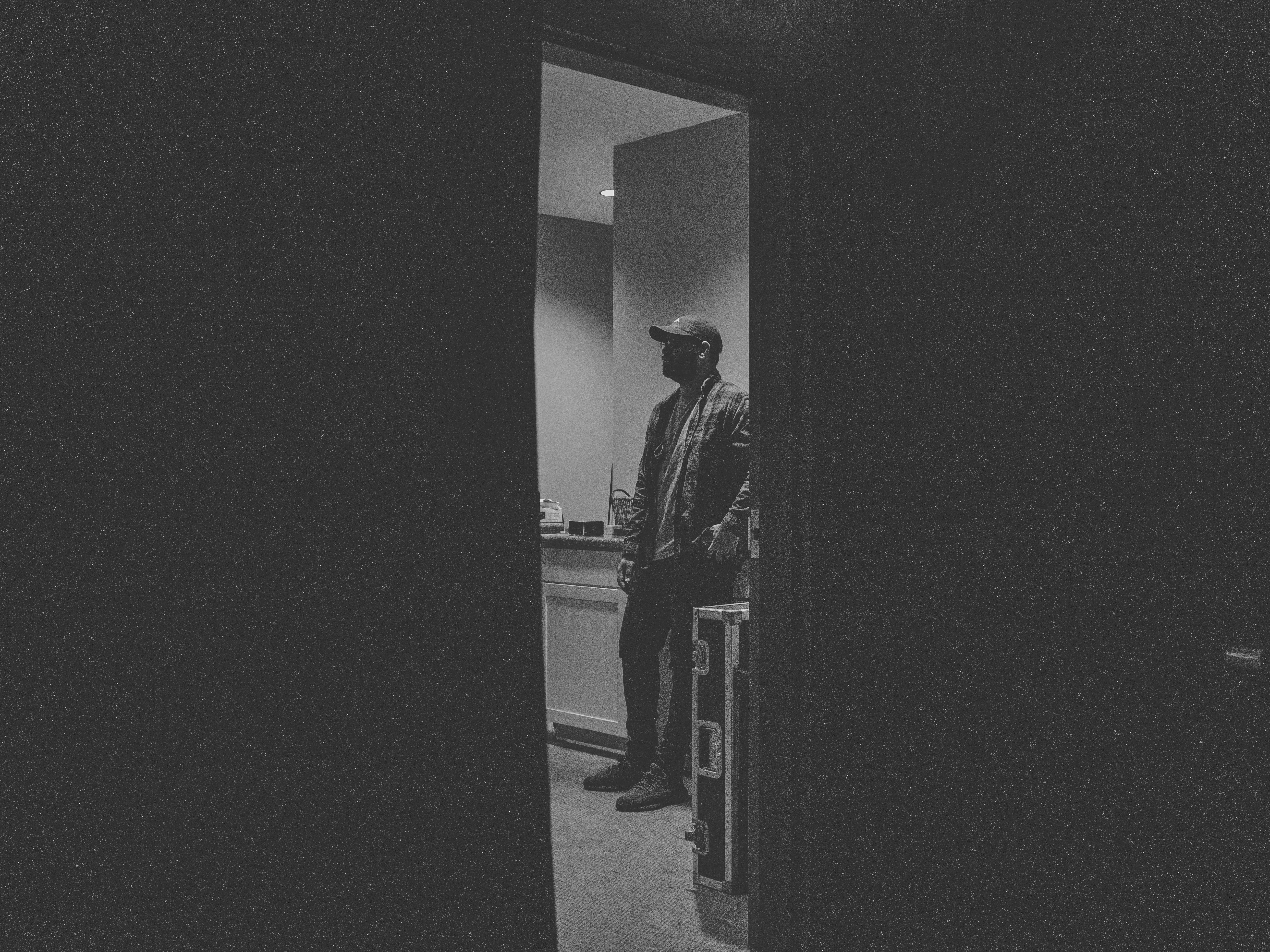 man in black coat walking on hallway