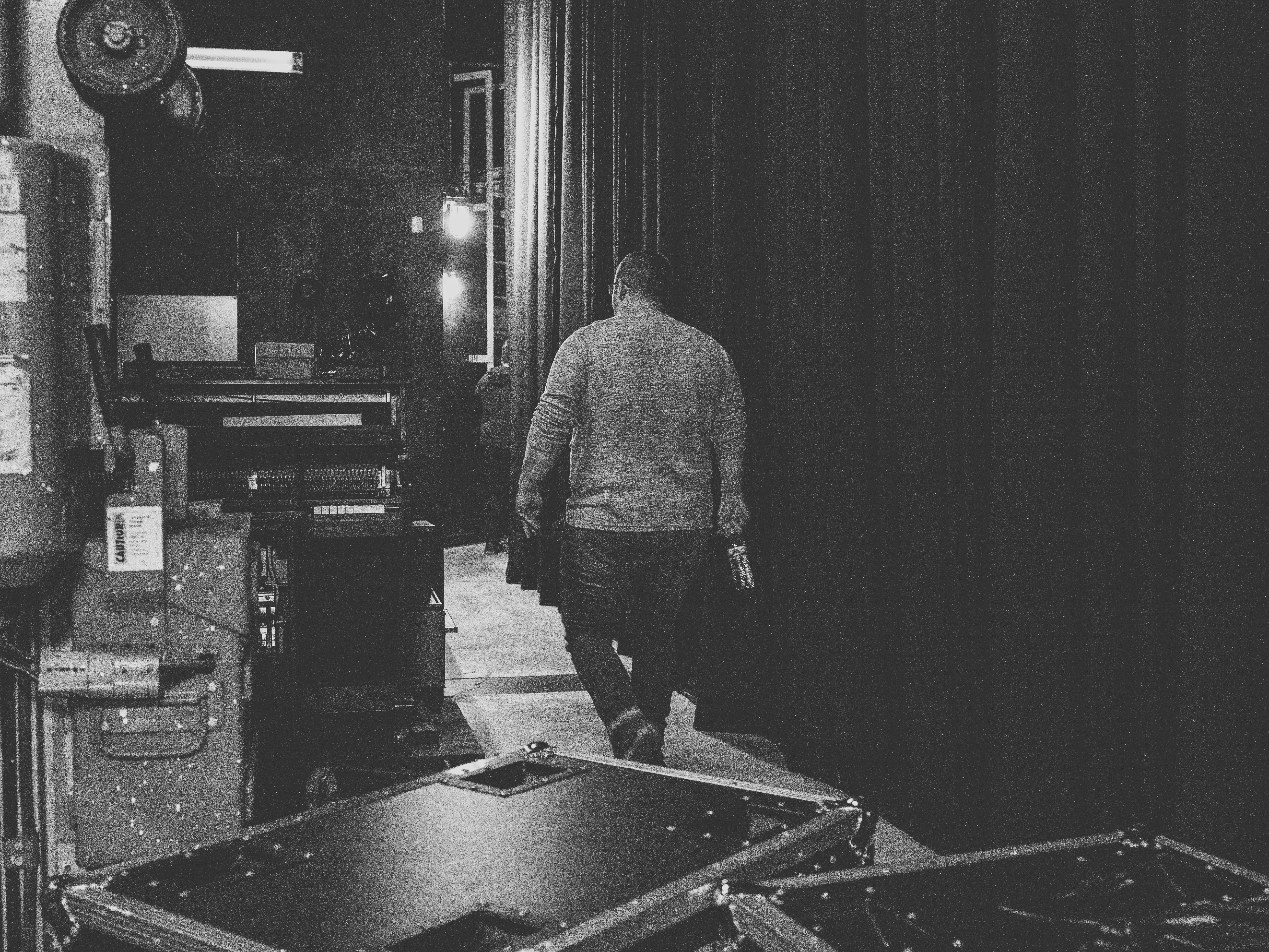 man in gray dress shirt standing beside counter