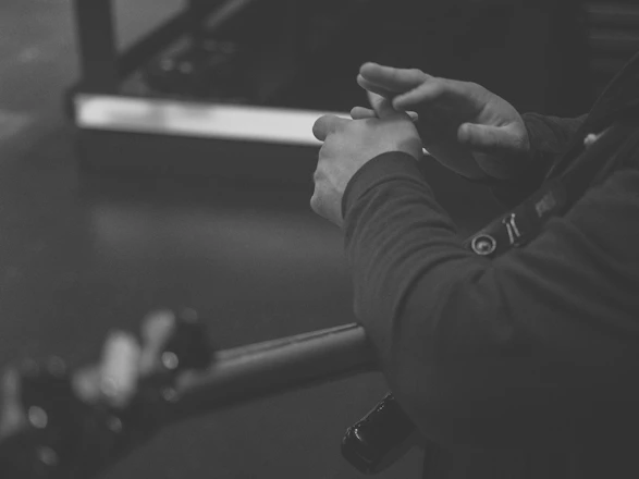 A close-up of hands typing on a laptop with sheet music and a guitar nearby.