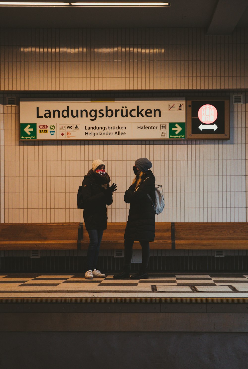 man and woman standing on brown wooden bench