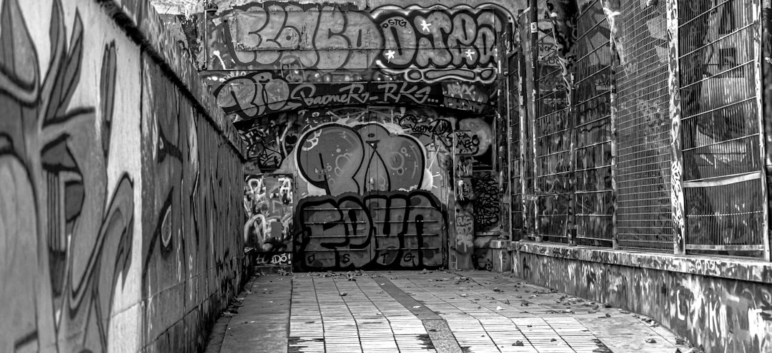 grayscale photo of graffiti on wall,