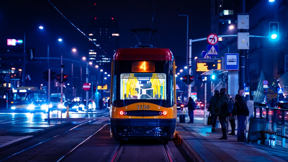 rot-weiße Straßenbahn nachts auf der Straße