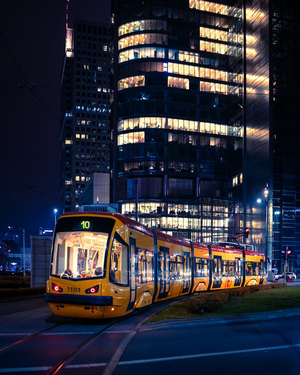 gelb-schwarze Straßenbahn nachts auf der Straße