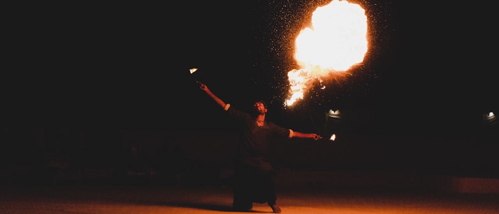 man in black jacket holding fire