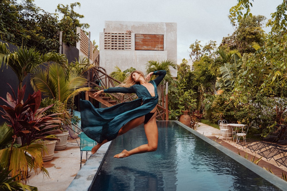 Mujer en vestido azul sentada en la piscina durante el día