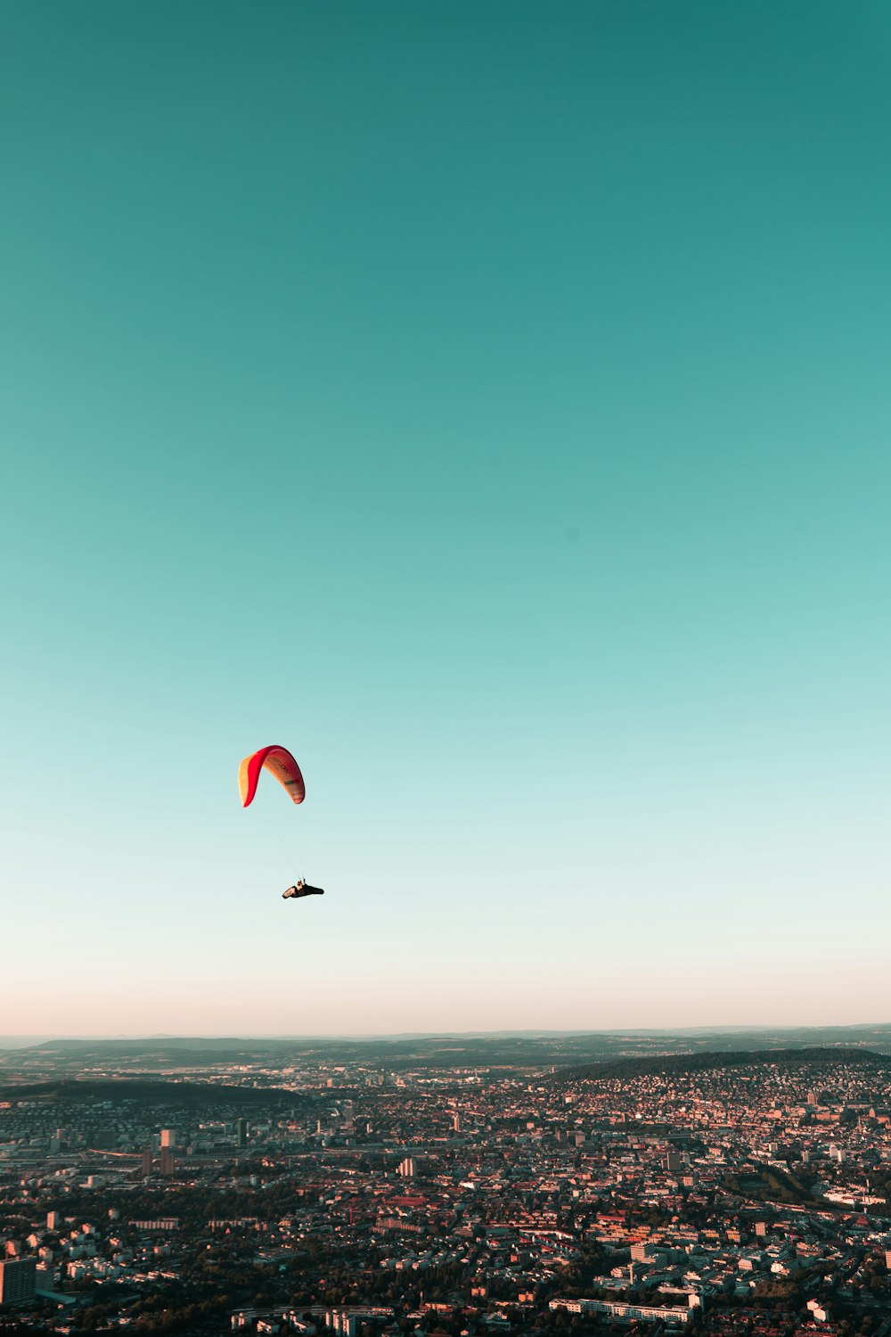 person in red parachute over sea during daytime