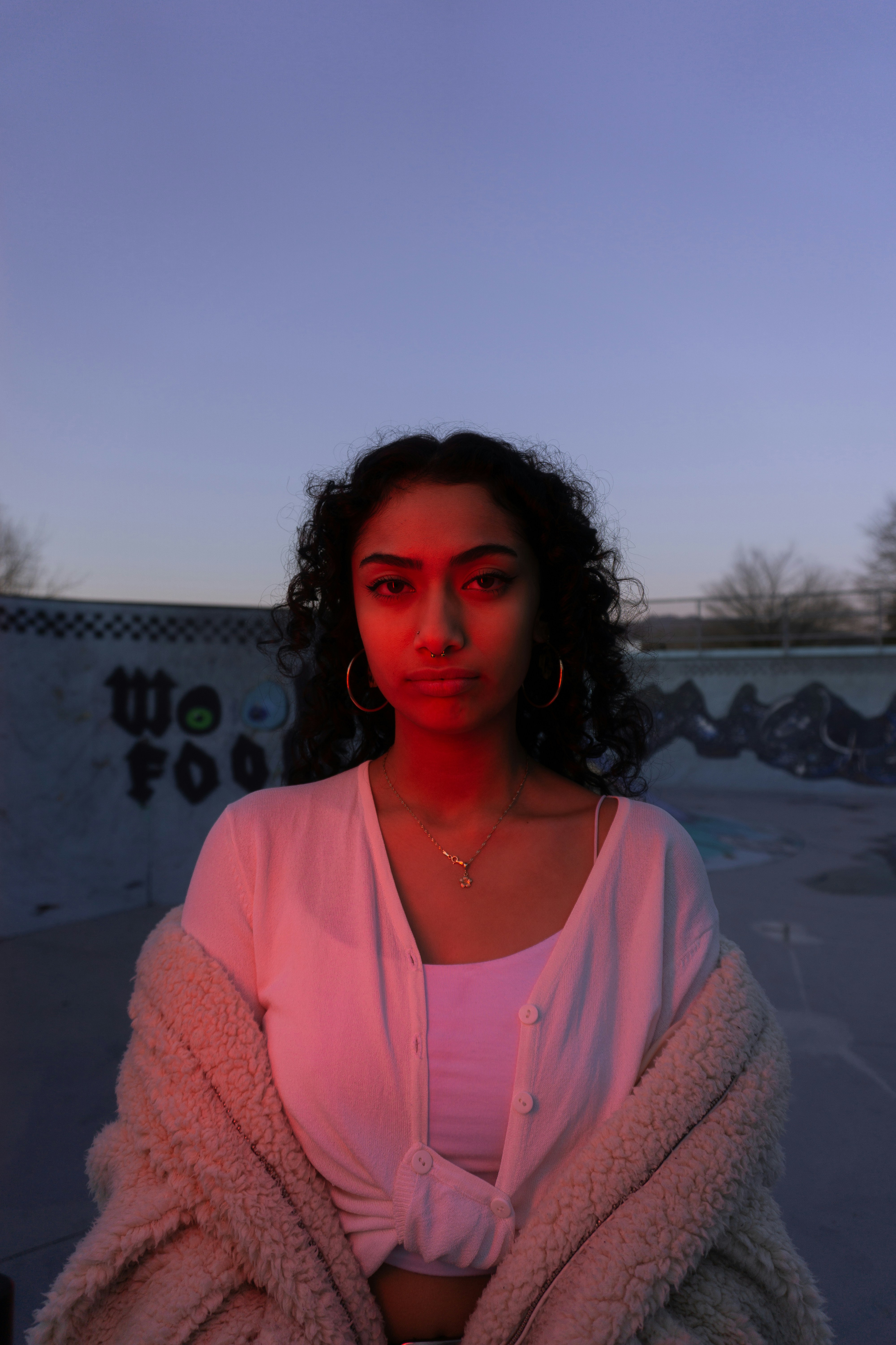 a woman in a white shirt and a pink jacket