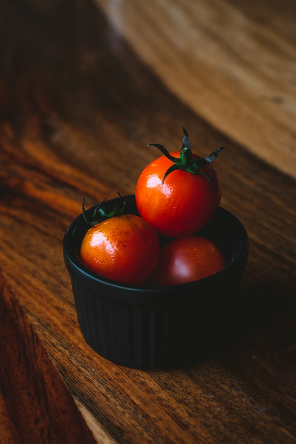 tomate rouge sur récipient en céramique noire