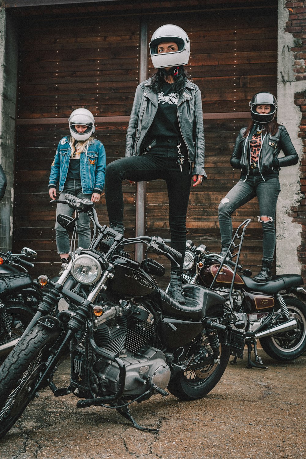 man in black jacket and blue denim jeans riding on black motorcycle