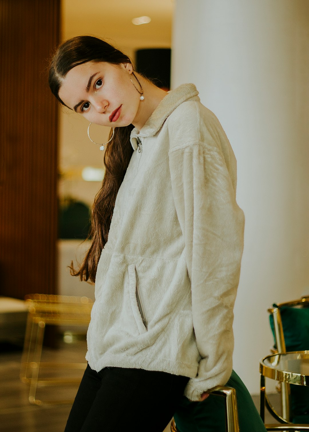 woman in white coat standing near brown wooden table