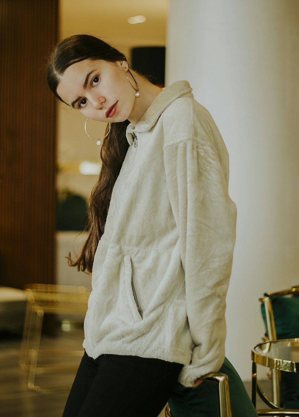 woman in white coat standing near brown wooden table