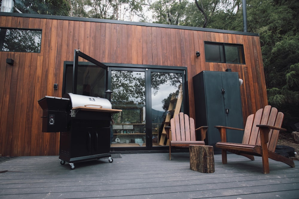 black and white gas grill beside brown wooden wall