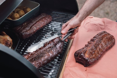 person slicing meat on tray