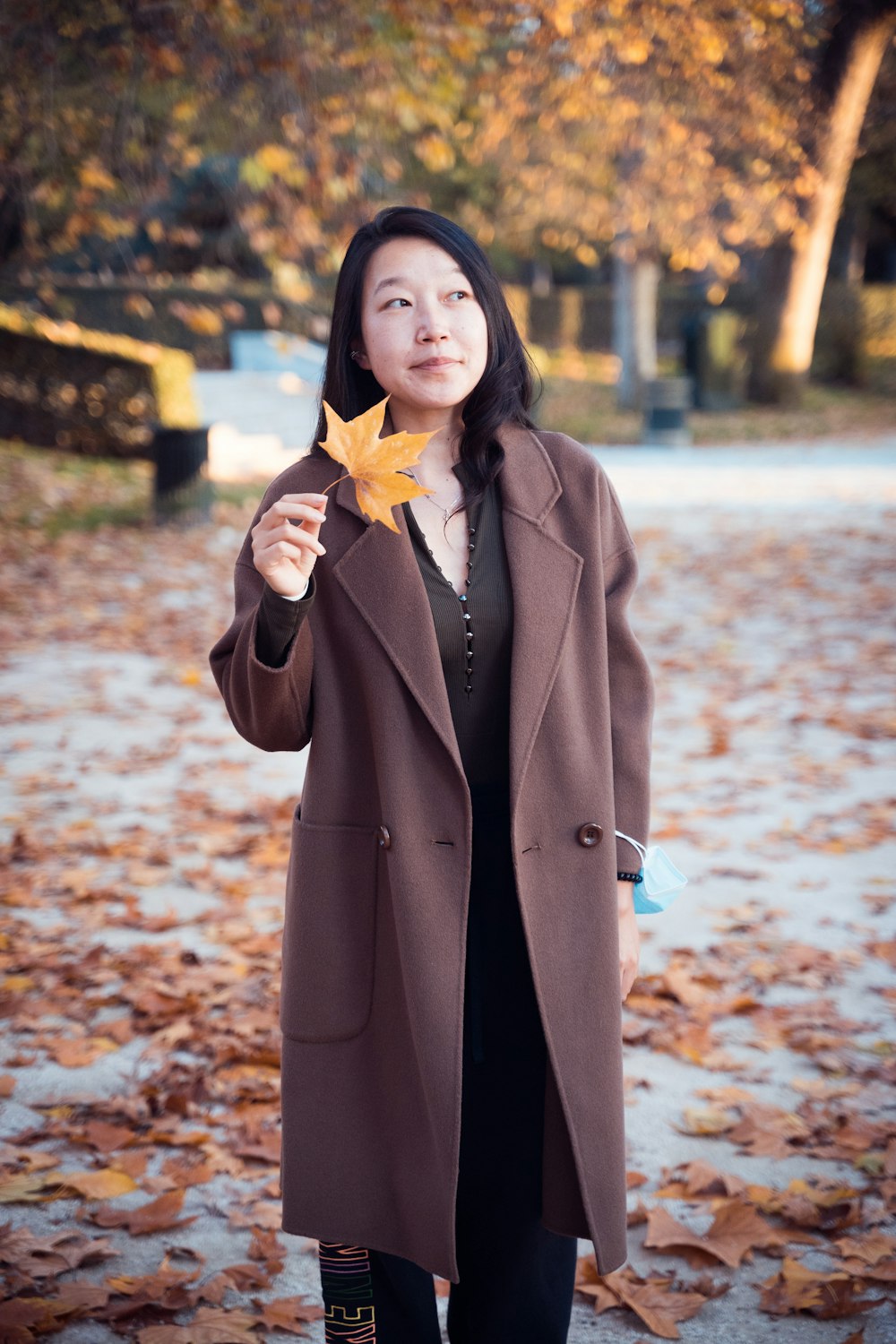 woman in brown coat standing on snow covered ground during daytime