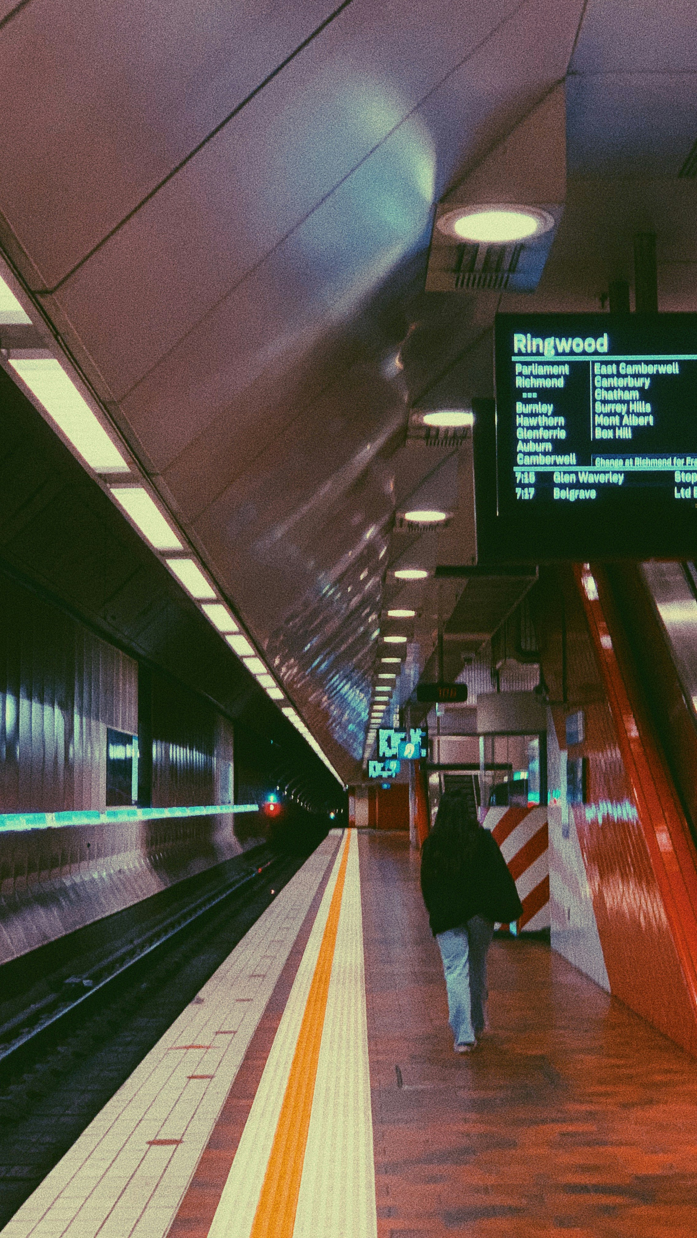 man in black jacket walking on train station