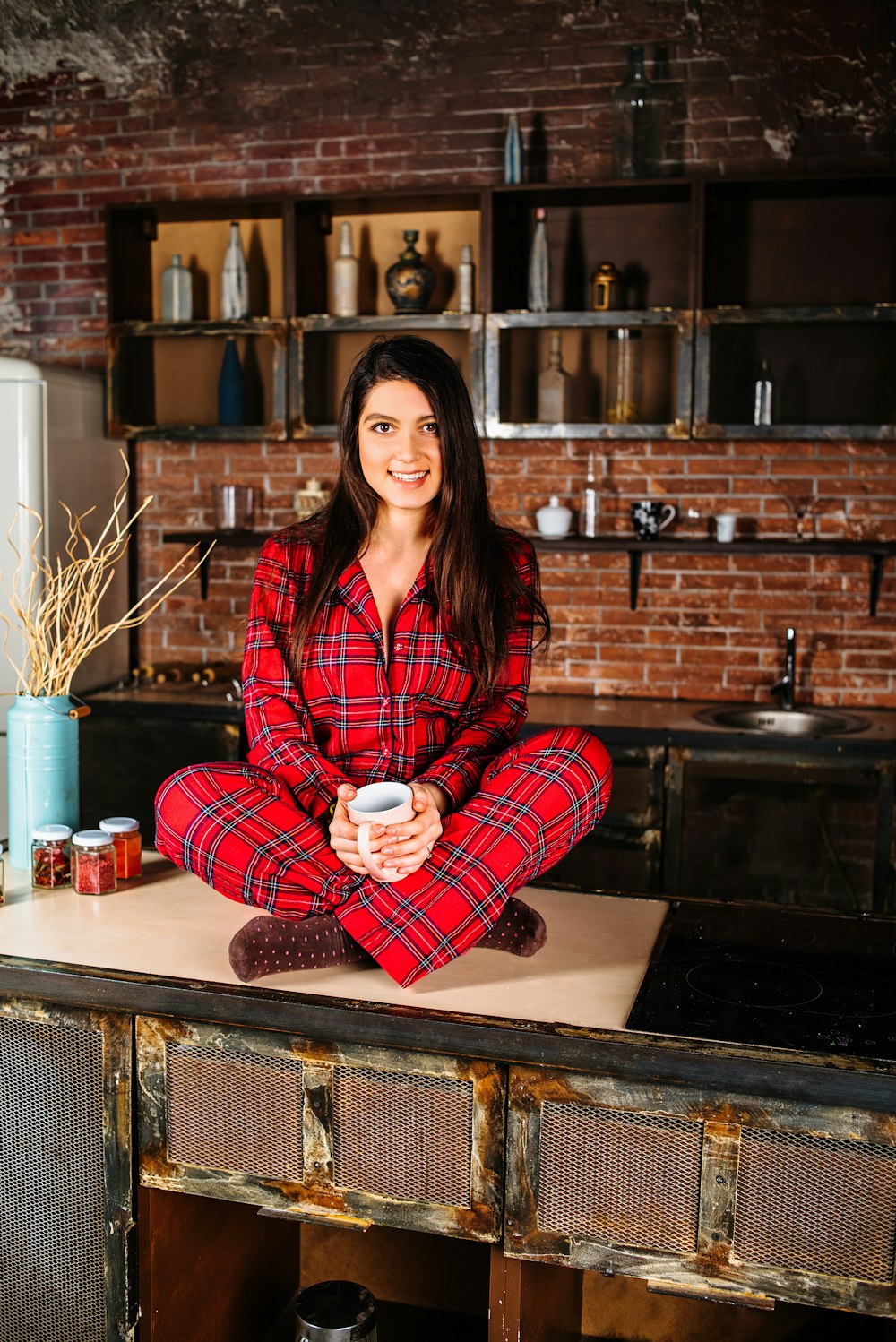 woman in red and white plaid coat sitting on brown wooden table
