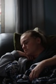 woman in black shirt lying on couch