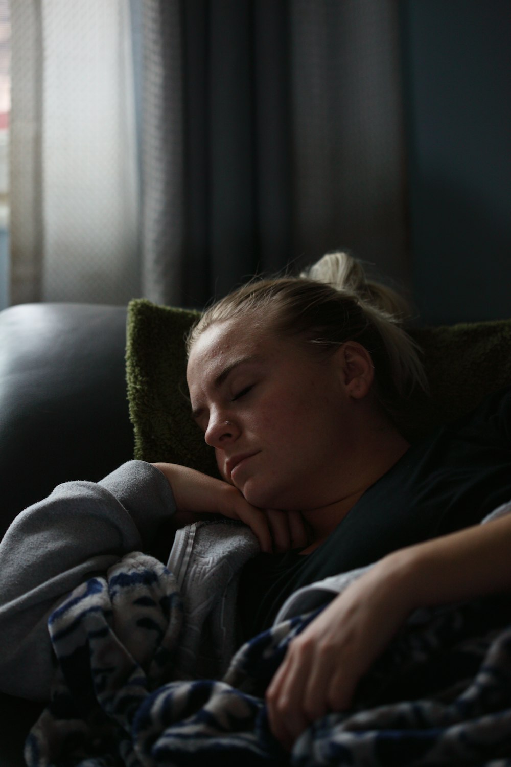 woman in black shirt lying on couch