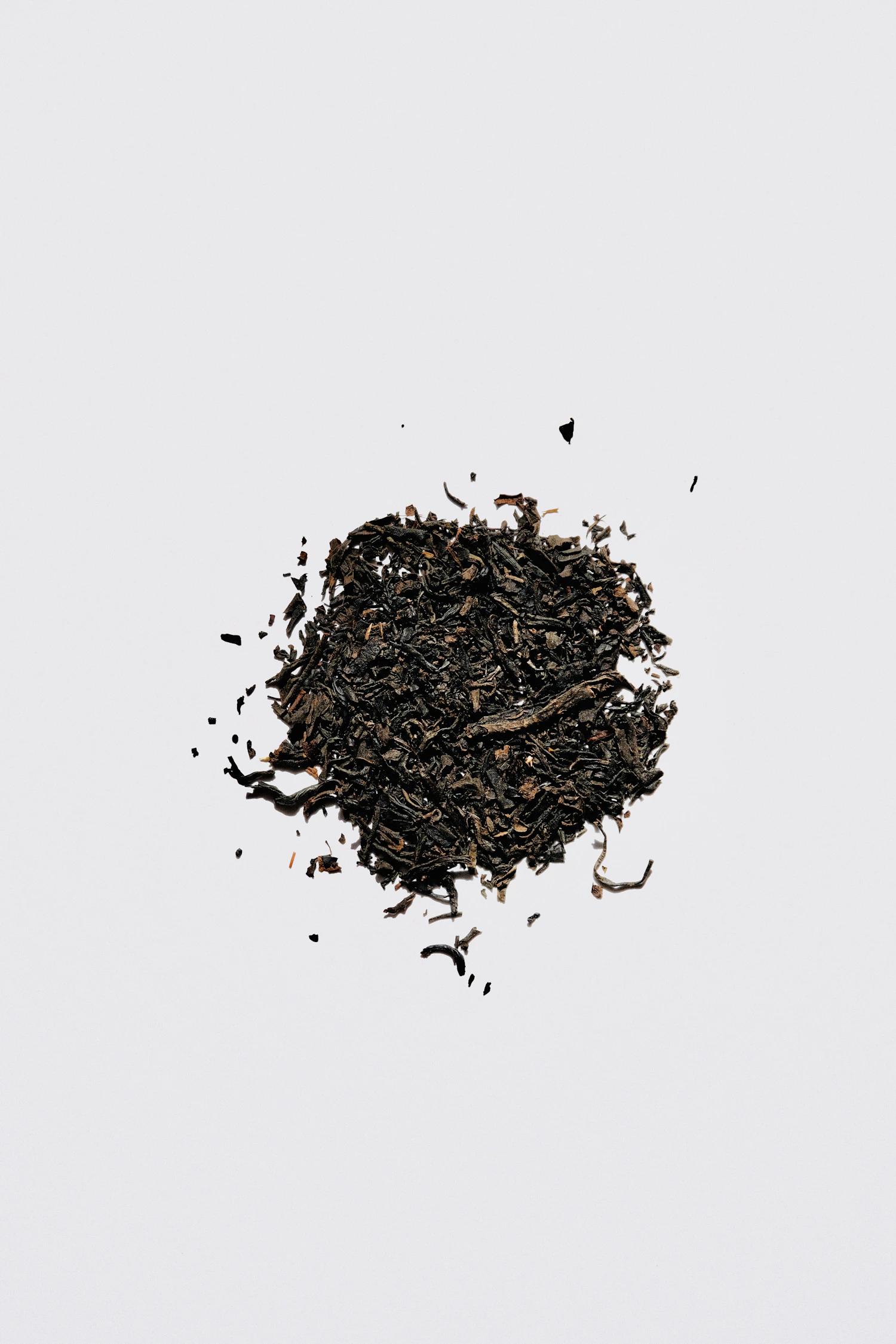 Wiry brown second-flush Darjeeling leaf spread on a pale surface, in stock
