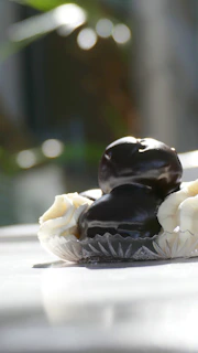 A close shot of a decadent dessert display with rich chocolate, cream, and elegant swirls on cream-colored dishes