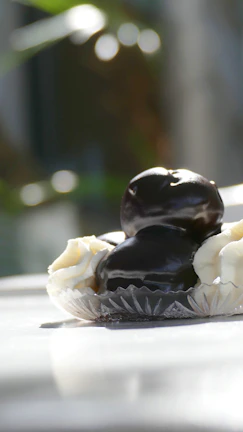 A close-up of a decadent dessert artfully presented on fine china with a backdrop of soft cream and burgundy hues.