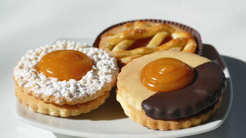 two brown donuts on white ceramic plate