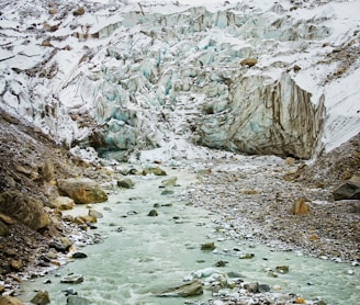 rocky river between rocky mountains during daytime