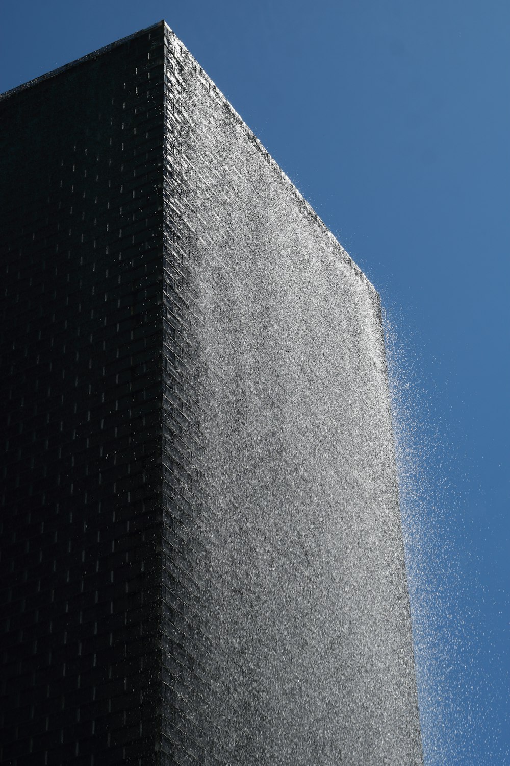 Graues Betongebäude unter blauem Himmel tagsüber