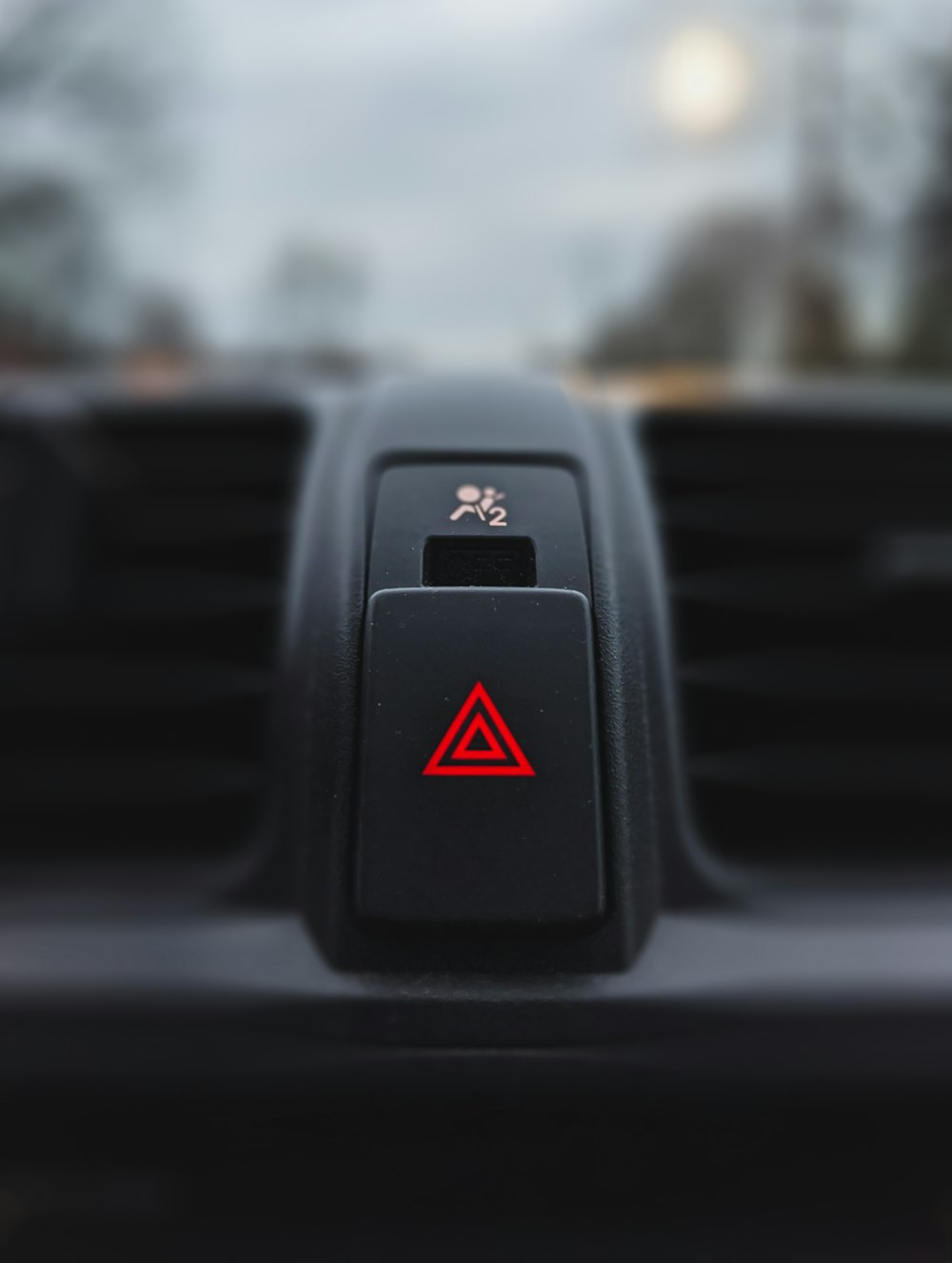 a close up of a car's air vent with a red triangle on it