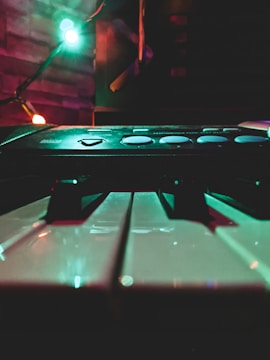 Close-up of vintage analog synthesizer keys glowing under moody lighting.