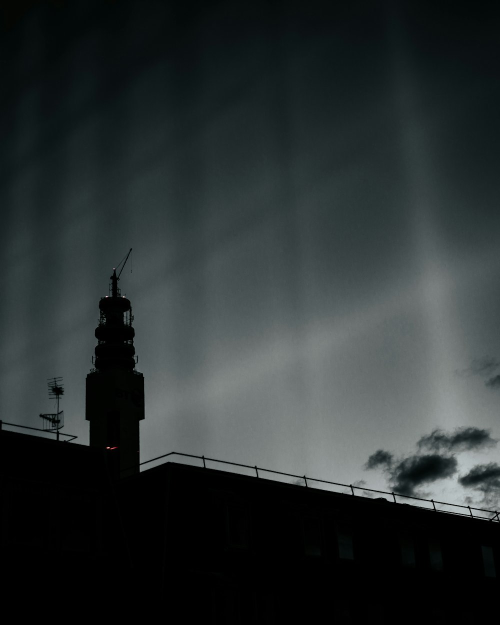 silhouette of tower under cloudy sky