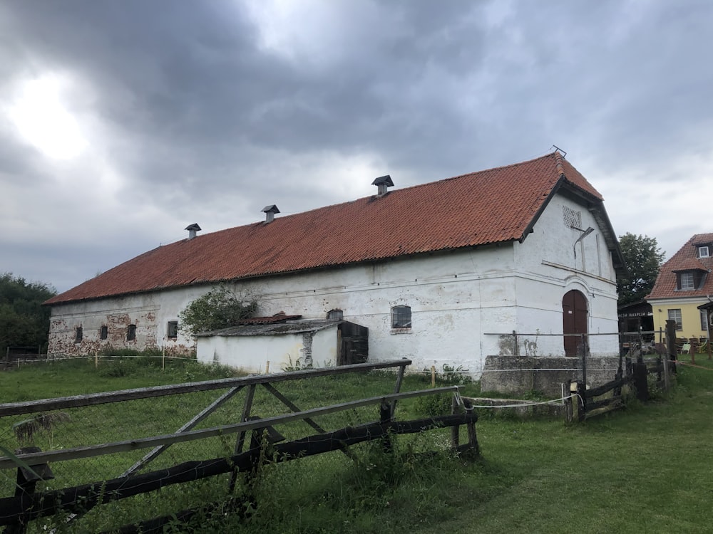 white and red concrete house under white clouds during daytime