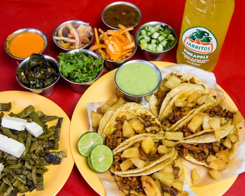 A vibrant plate of tacos al pastor with fresh pineapple and cilantro on a rustic wooden table.