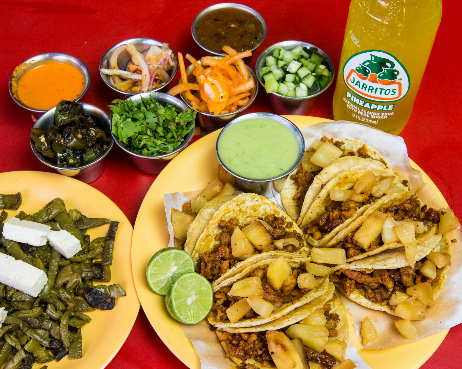 A colorful plate showcasing a variety of tacos with different fillings, accompanied by lime wedges and a side of spicy salsa.