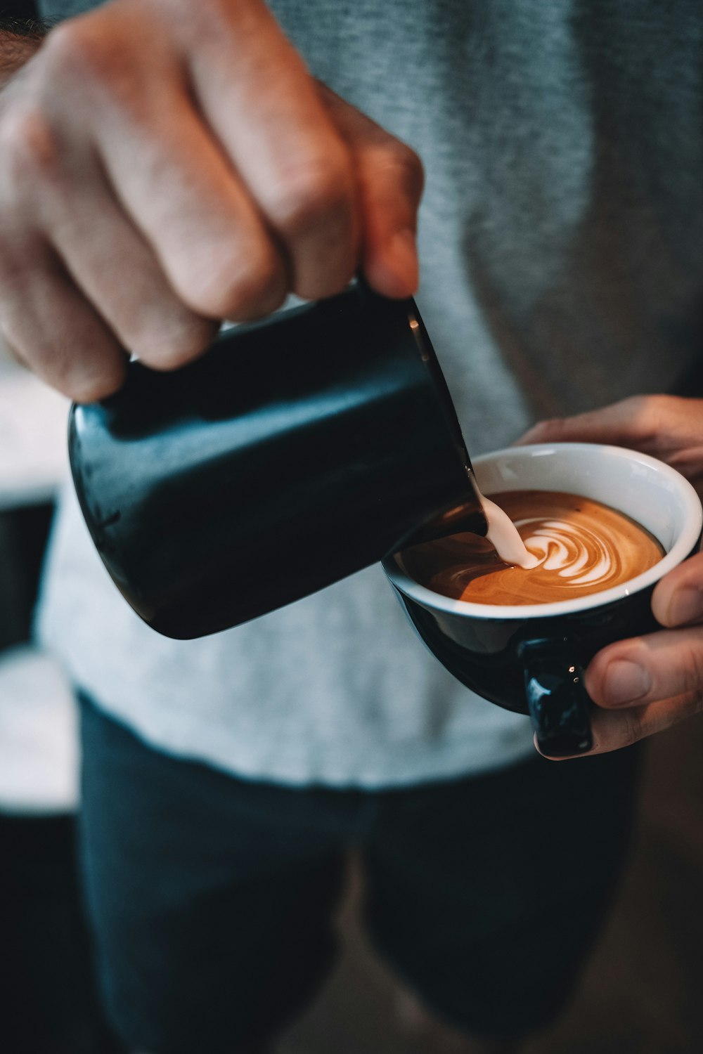 person holding black ceramic mug with brown liquid