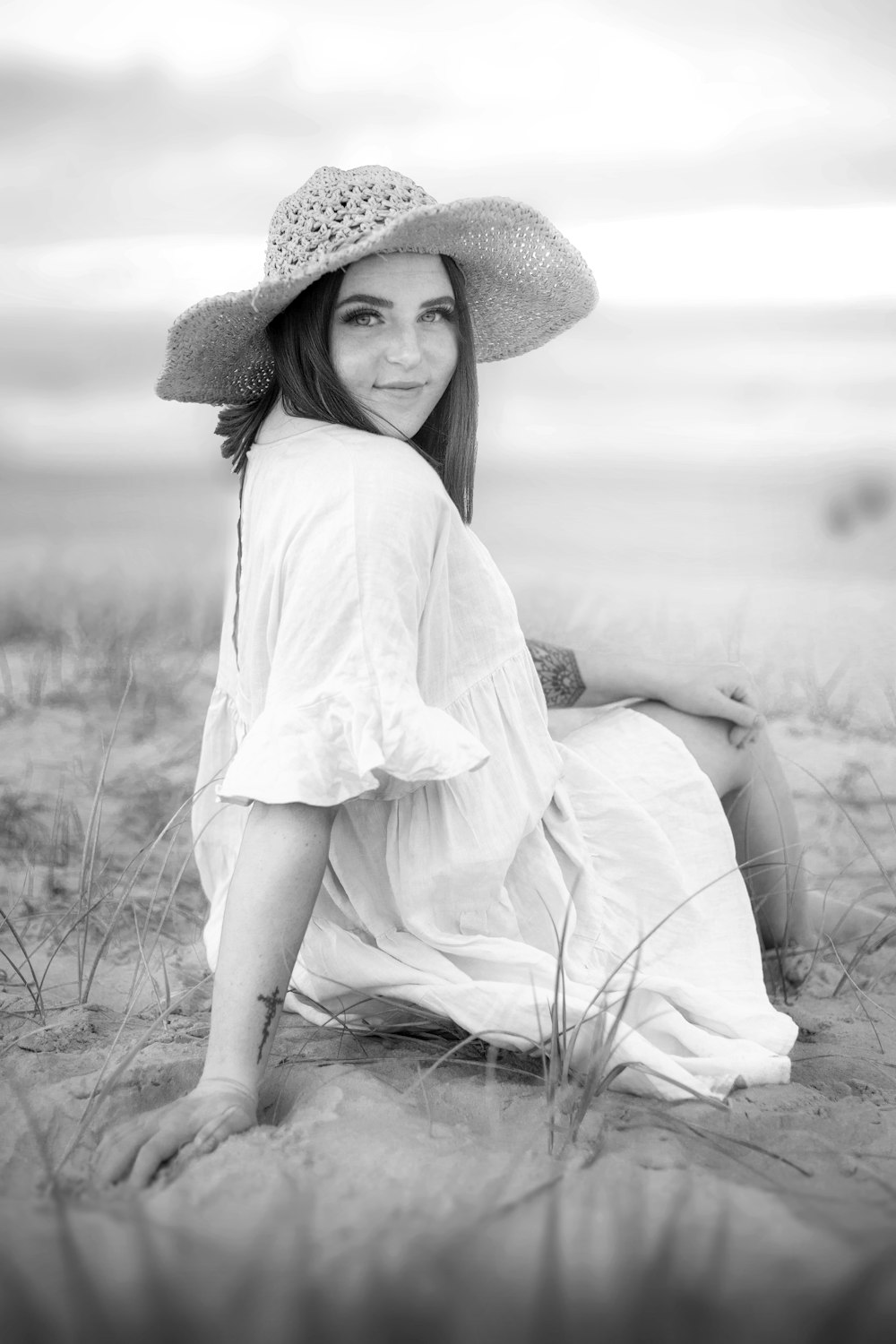 woman in white dress sitting on grass field