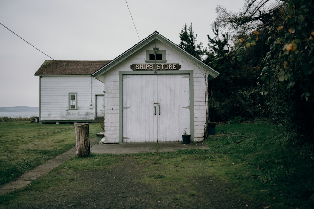 white wooden house near green trees during daytime