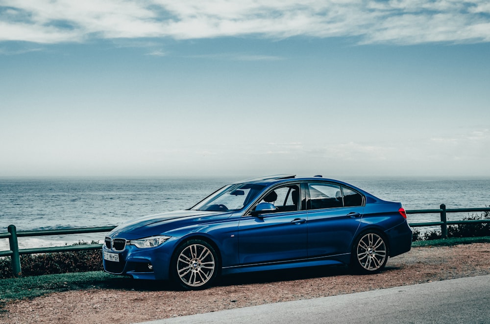 blue bmw m 3 coupe parked on seashore during daytime