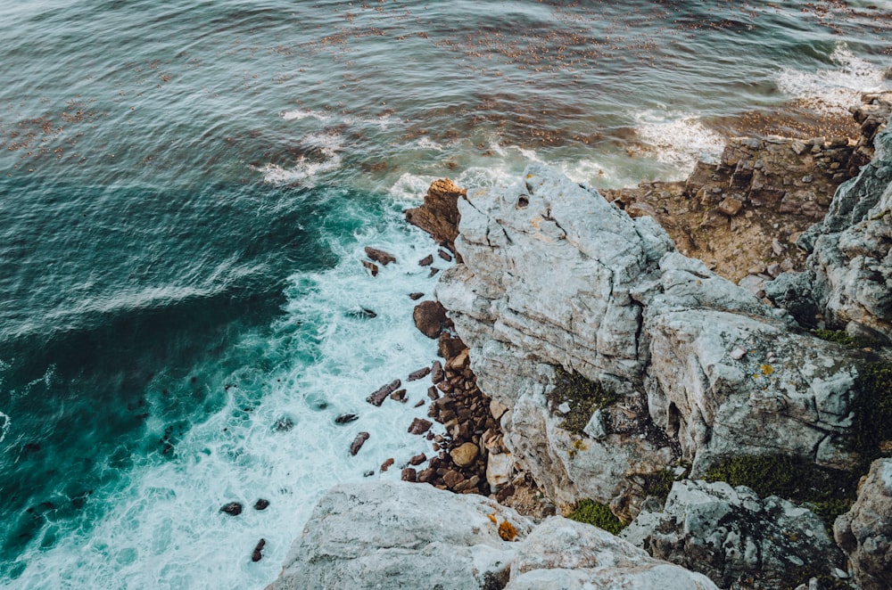 brown rock formation beside body of water during daytime