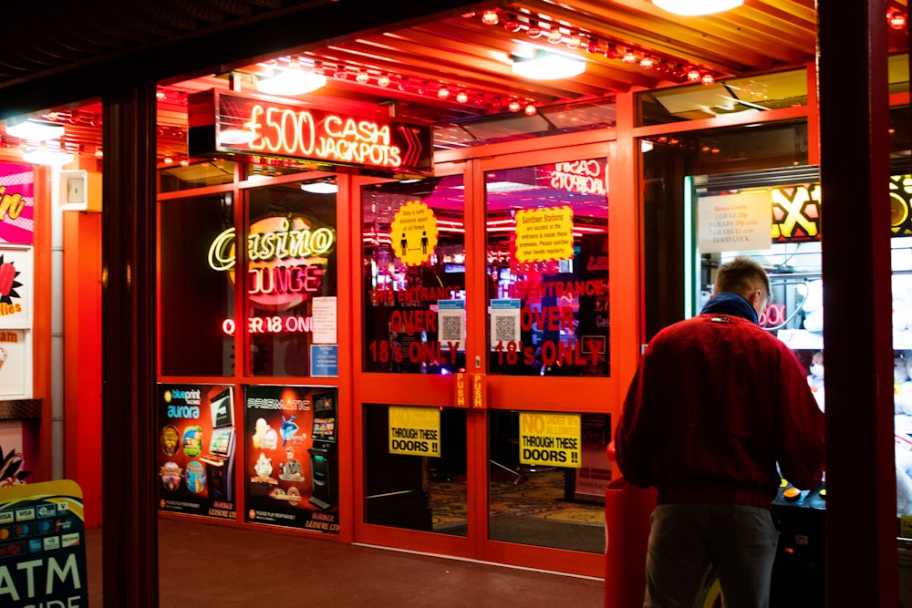 man in red shirt standing near store