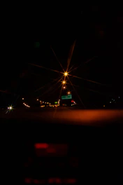 A nighttime highway stretching into the distance, illuminated by golden streetlights with a sleek car dashboard glowing softly.